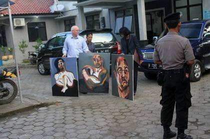 Bali nine lawyer, Julian McMahon, with three recent paintings by Myuran Sukumuran, among them one marked "Self Portrait, 72 hours just started" as Sukumuran began the countdown to his execution. Photo: Amilia Rosa