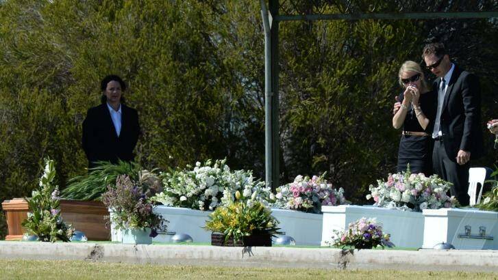 Kim Hunt's sister Jenny Geppert grieves over the coffins of Geoff and Kim Hunt and their children Fletcher, Mia and Phoebe, at a service in Lockhart in 2014. Photo: DEAN LEWINS