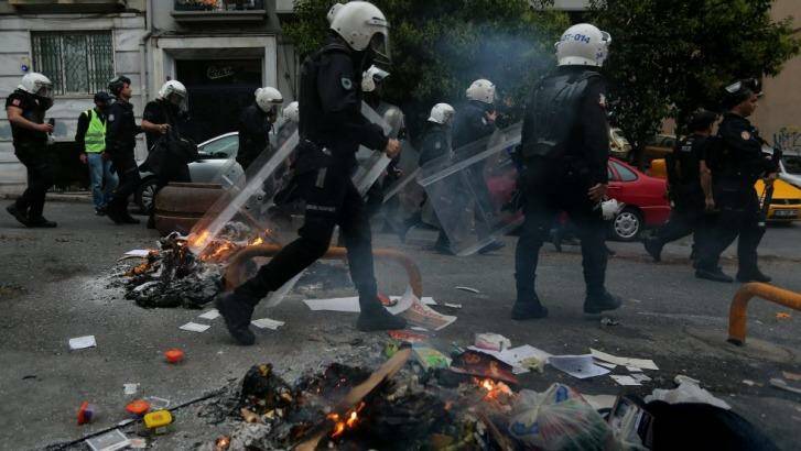 Protest: police walk past burning debris in the Cihangir district of Istanbul. Photo: Kate Geraghty