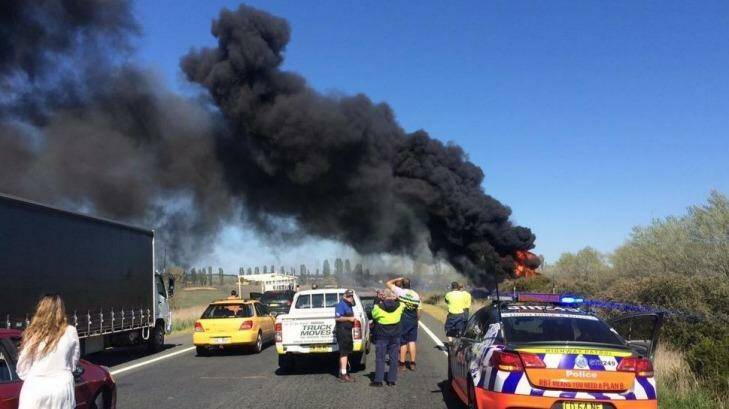 A truck has rolled and caught fire on the Federal Highway. Photo: Carl Butchard via @CarlThruTheLens