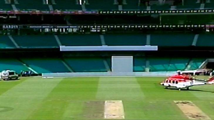 A chopper arrives on the SCG to transport Hughes from the ground.