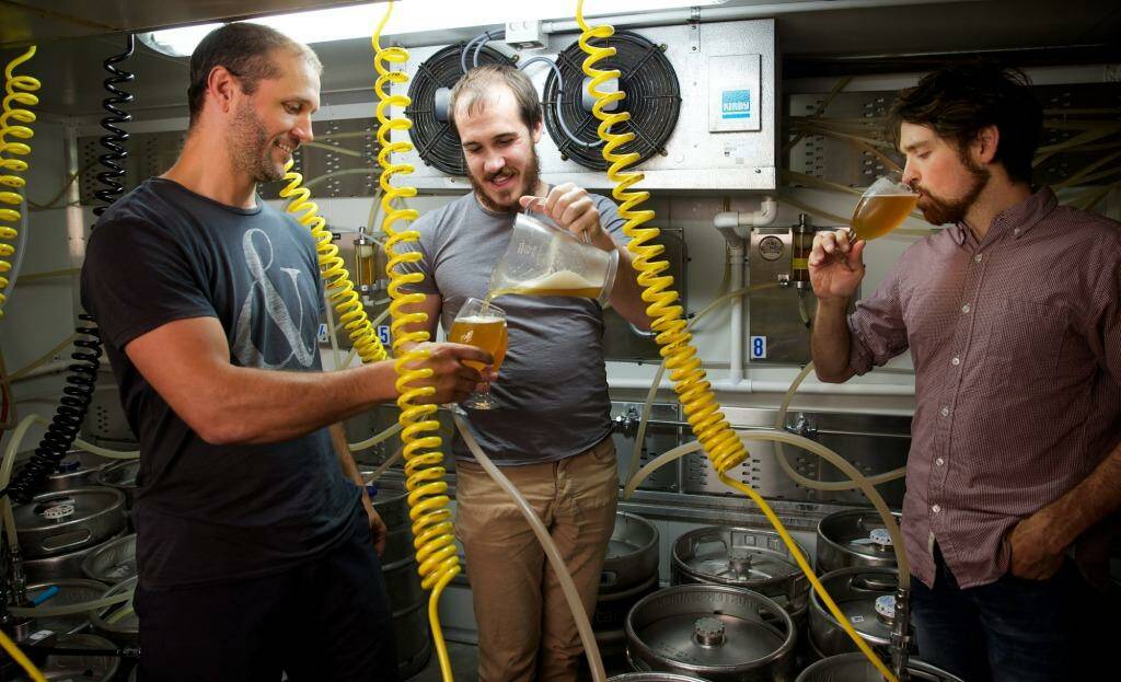 Fizzing: Scientists and amateur beer brewers Scott Brownless, centre, and Chad Husko, right, sample one of their creations with Alex Judge. Photo: Wolter Peeters