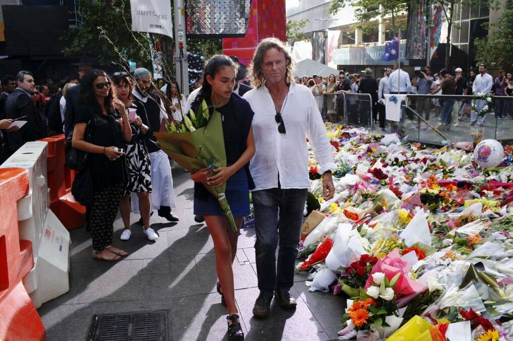 Tributes: Tori Johnson's father Ken and sister at the Martin Place memorial. Photo: James Brickwood