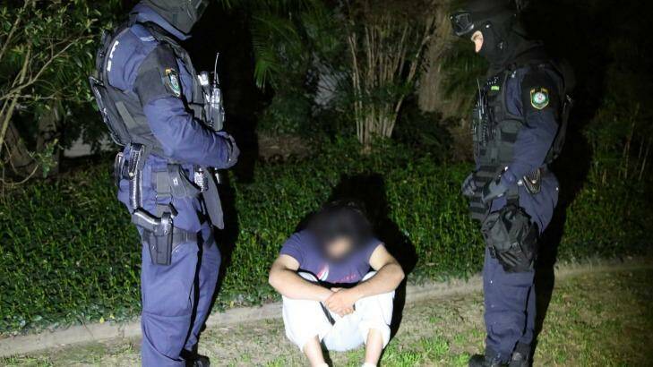 Maywand Osman is detained during the pre-dawn Operation Appleby raids in September 2014. Photo: NSW Police