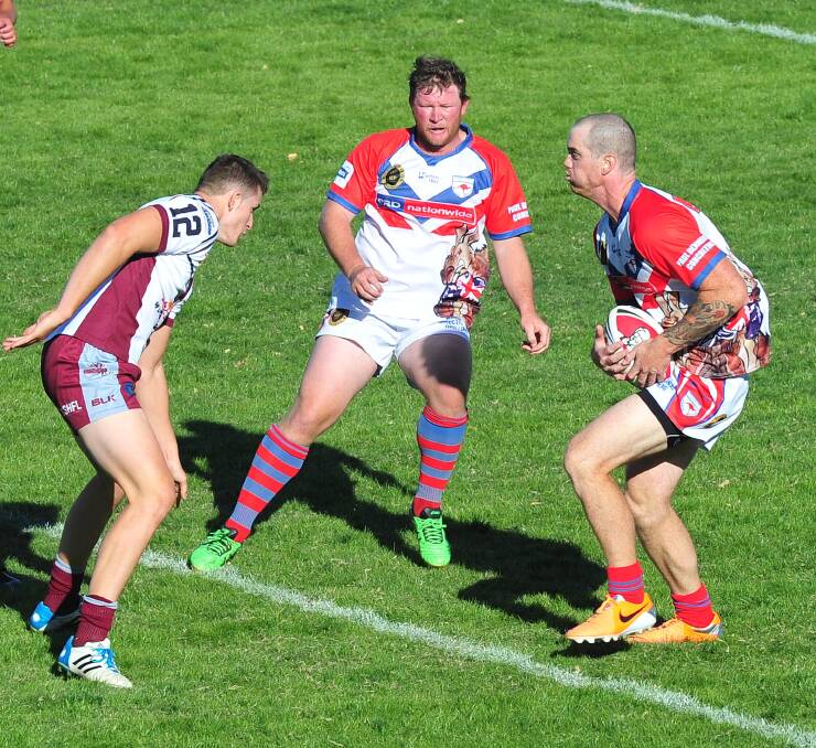 Queanbeyan Kangaroos player Jed Pearce attempts to stop Wagga's Adam Hall and Hayden

Brookes at the Charity shield rugby league event at Wagga Wagga. Photo: Kieren L Tilly.