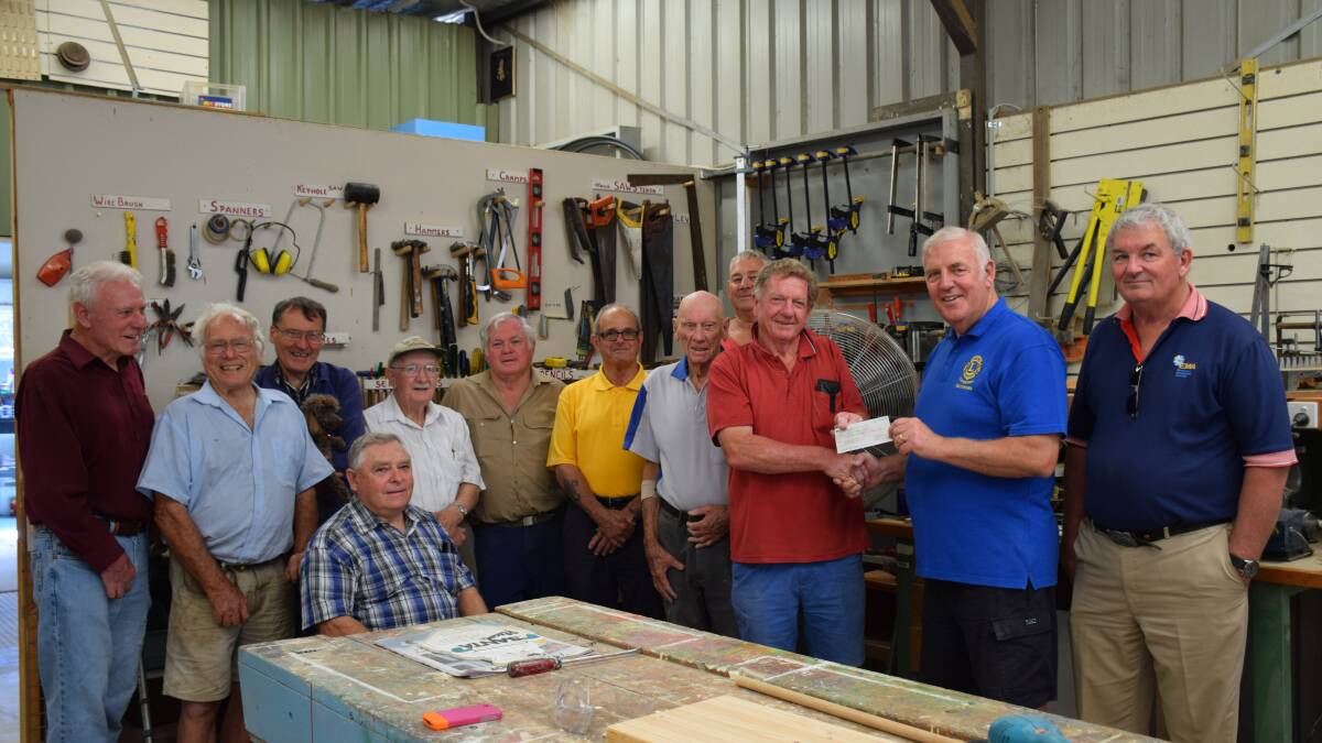 Gary Jones from Belconnen Lions Club presents Denny Christensen with a cheque to support the work of the Queanbeyan Men's Shed.