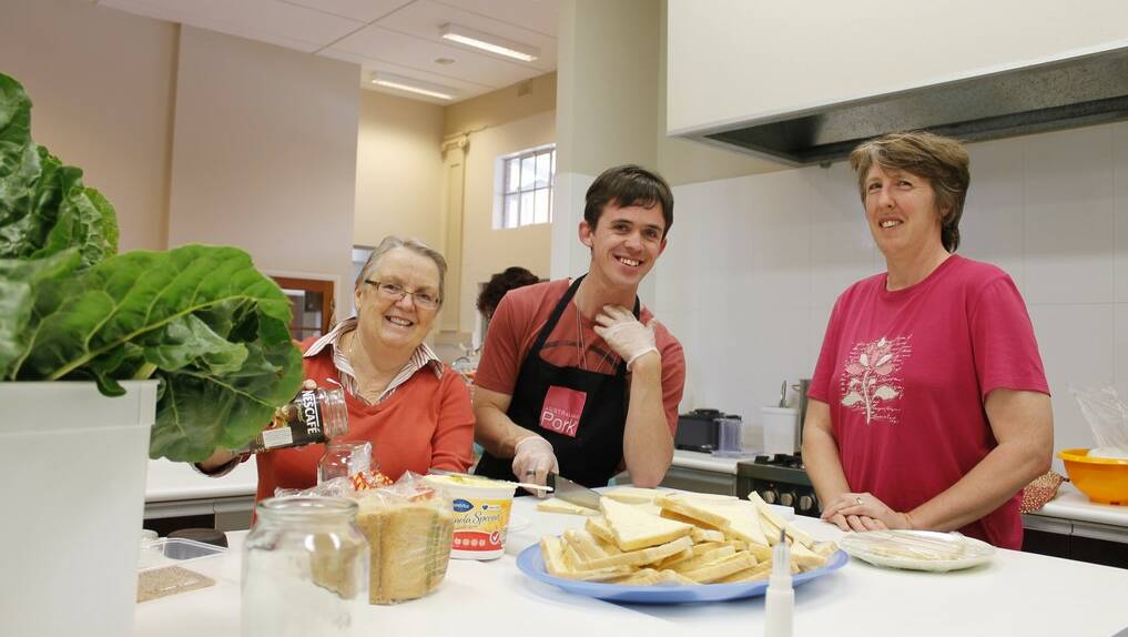 St Benedict's volunteers Annette Stace, Robbie Leahy and coordinator Elaine Lollback prepare lunch at the Queanbeyan community centre.