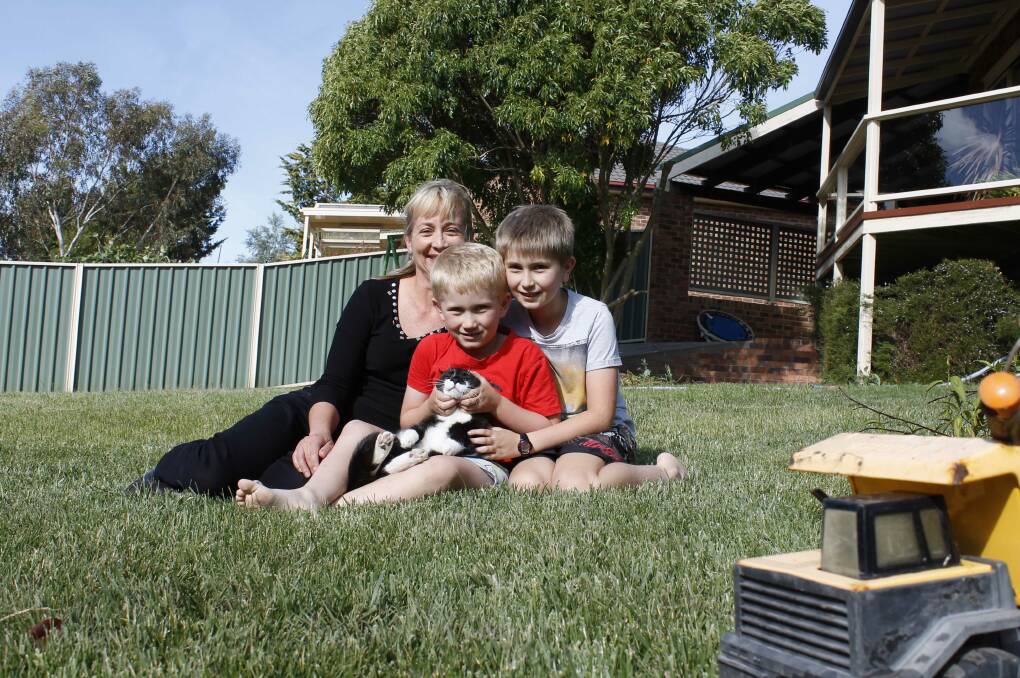 Jerrabomberra residents Margot Sachse with her sons Aiden (6) and Angus (9) Davies and Wilbur the cat.