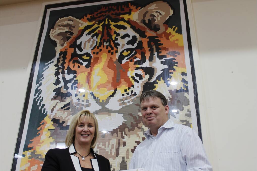 Queanbeyan Hospital manager Kim Bradshaw collects a cheque for $11,000 from Queanbeyan Tigers Club general manager Mark White.