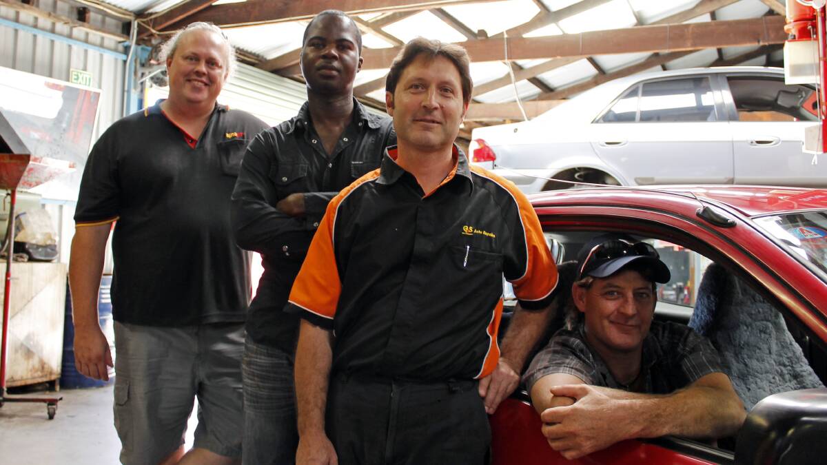Queanbeyan man Garry Graham in his new car, restored and donated to him by local automotive business reps (from left) Andrew Brown of Autopro, Ambrose 'Phil' Agbonzikilo of RE' Spares and Tony Guglielmin of G&S Auto Repairs.