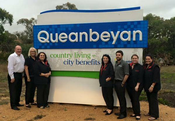 The Queanbeyan Travel and Cruise team couldn't resist a photo op with the town sign. Photo: @qbntravel.
