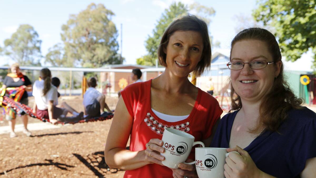 Year 2/3 teacher Penny Lock and Queanbeyan Public School P&C president Kym Bush with some of the school's special merchandise to mark 150 years.