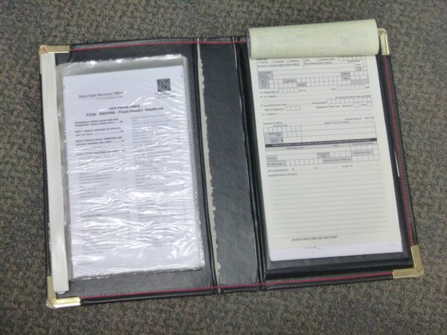 An example of a NSW Police-issued torch and Traffic Infringement Book that has been stolen in recent weeks. Police would like these items returned.