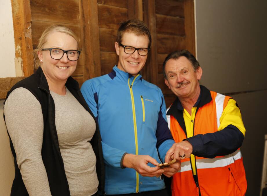 Queanbeyan residents Lauren Rogers and Jesse Gillard with their plasterer Aloys Kaminiski who discovered the old newspaper clipping wedged in the wall. Photos: Kim Pham.