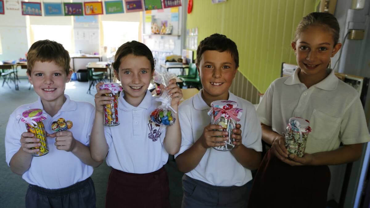 Queanbeyan Public School students William Bush, Emerson Whipp, Jacob Pulciani and Liana Aristotelous with an assortment of lollies they will be selling at the 150th Birthday Fete to raise money for the school. Photo: Kim Pham.