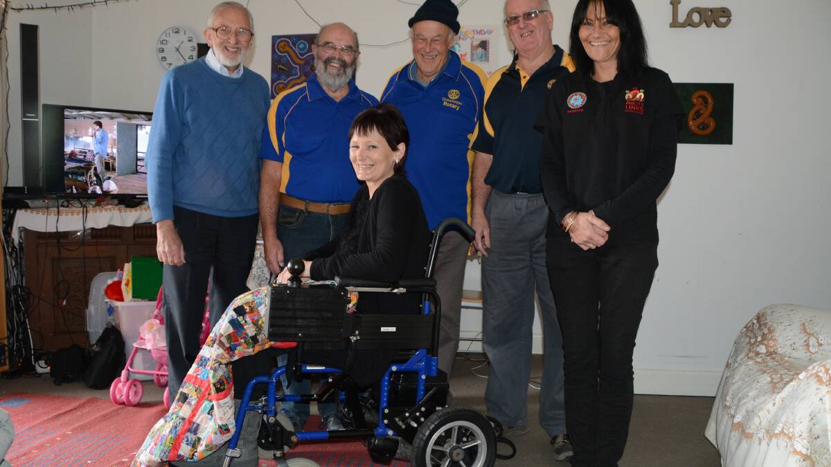 Michelle Smith is all smiles in her new wheelchair with Graham Waites from TADACT, Doug Mitchell, Tim Brown and Keith Edmonds from Queanbeyan Rotary and Rose McClure from Aboriginal Ability Links. Photo: Ron Aggs.