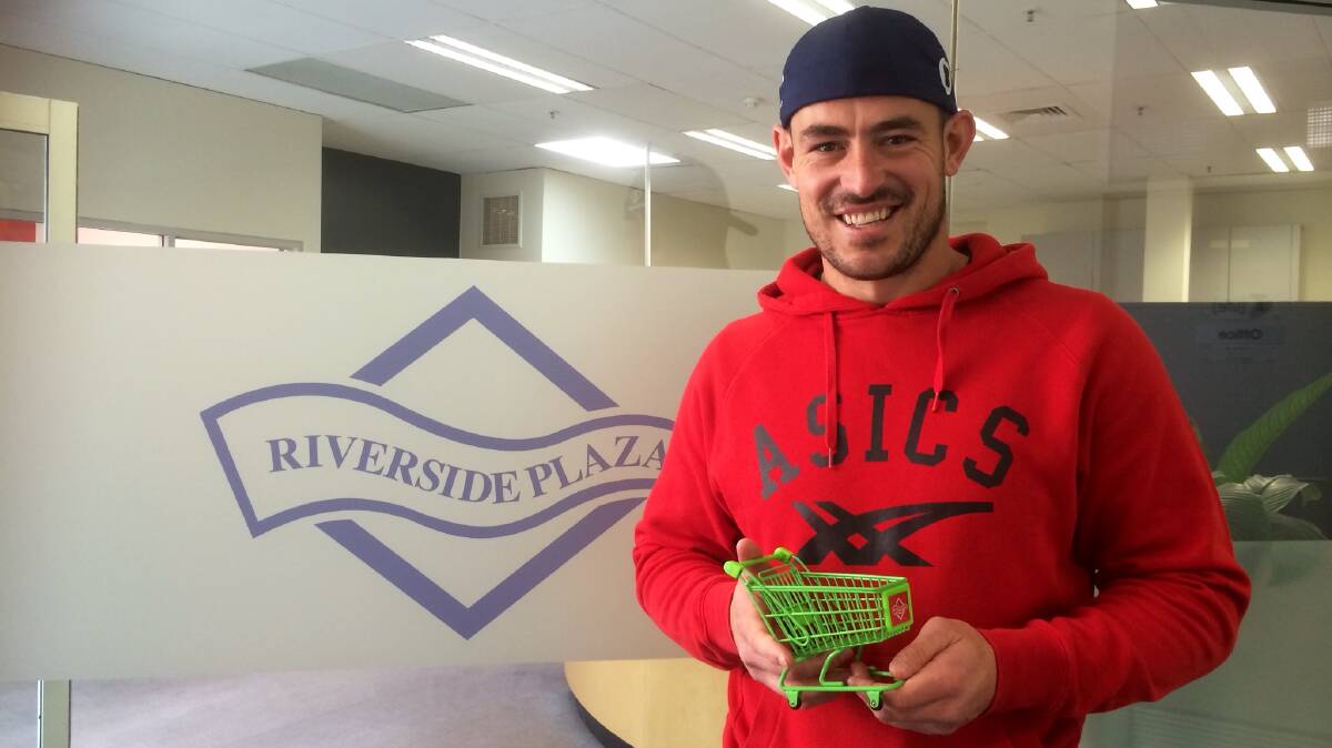 Former Riverside Plaza trolley collector and current Canberra Raiders player Terry Campese receiving a miniature trolley trophy in recognition of his past efforts. Photo: Heidi Flaherty, Riverside Plaza.
