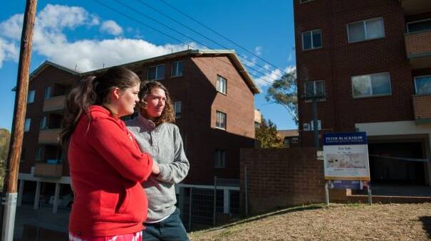 Neighbours Sarah Blackman and Kimberley Bell look on where a house fire in Queanbeyan killed a one-year-old girl.  Photo: Elesa Kurtz.
