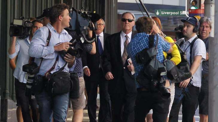 A media scrum surrounds Robert Hughes as he leaves the Downing Centre. Photo: Ben Rushton
