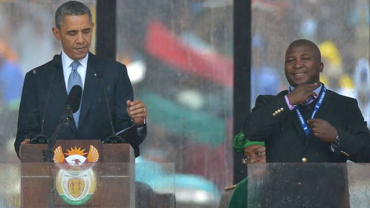 All smiles ... US President Barack Obama delivers a speech next to the fake sign language interpreter during the memorial service for late South African President Nelson Mandela in Johannesburg. Photo: AFP Photo