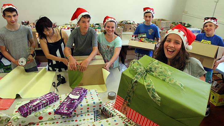 Sweet charity: Giselle Laszok (far right), who has been volunteering with Kids Giving Back, with a Christmas hamper. Photo: Peter Rae