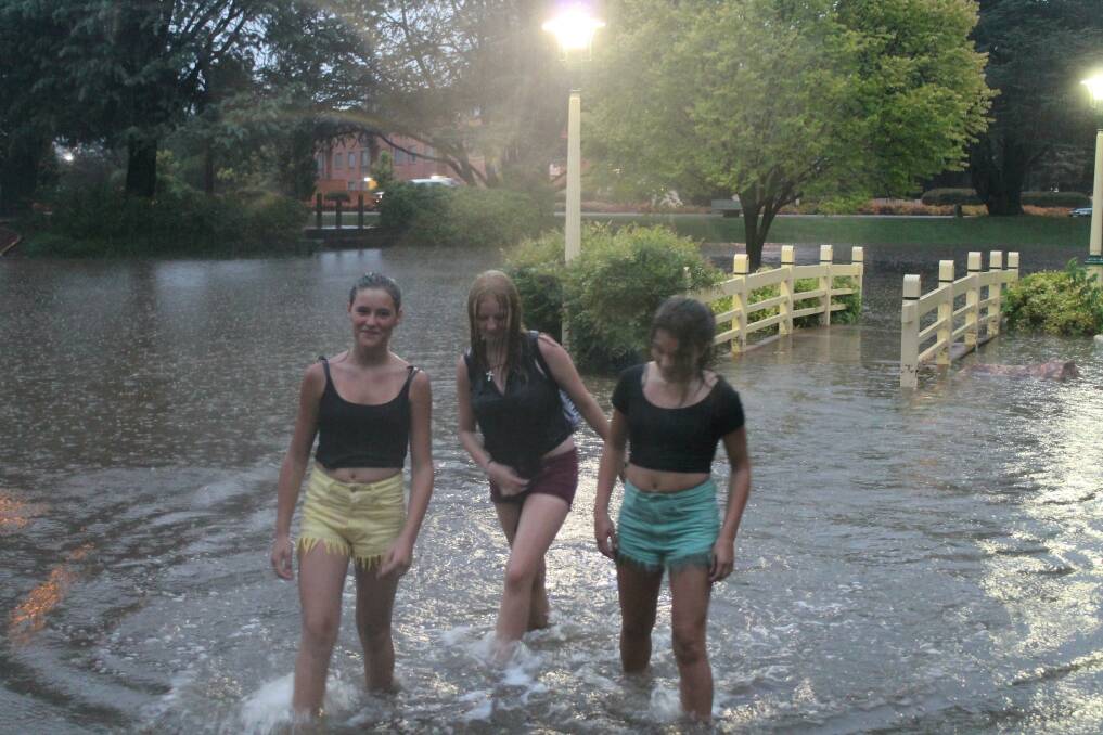 Tamara Ross (left), Mikaela Carlton and Millie Milson splash their way through the flood waters. 