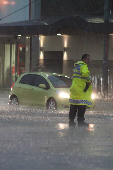 A police officer directs traffic at the Crawford and Monaro Street intersection. 
