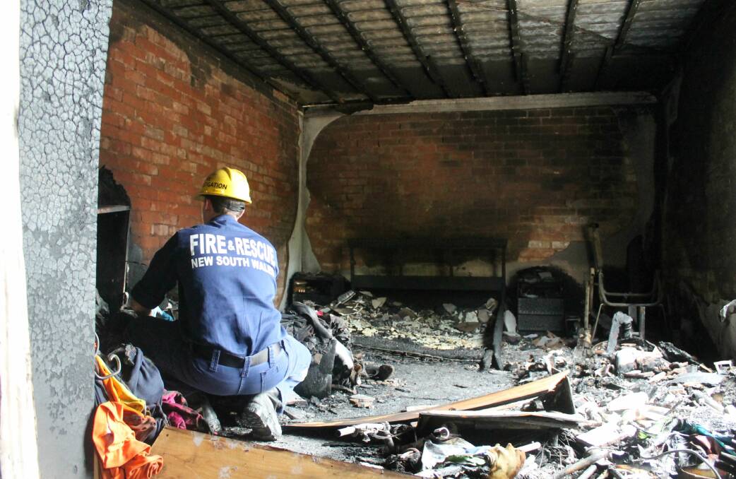 A NSW Fire Rescue investigator attempts to discern the cause of Sunday's fire. Photos: Andrew Johnston, Queanbeyan Age