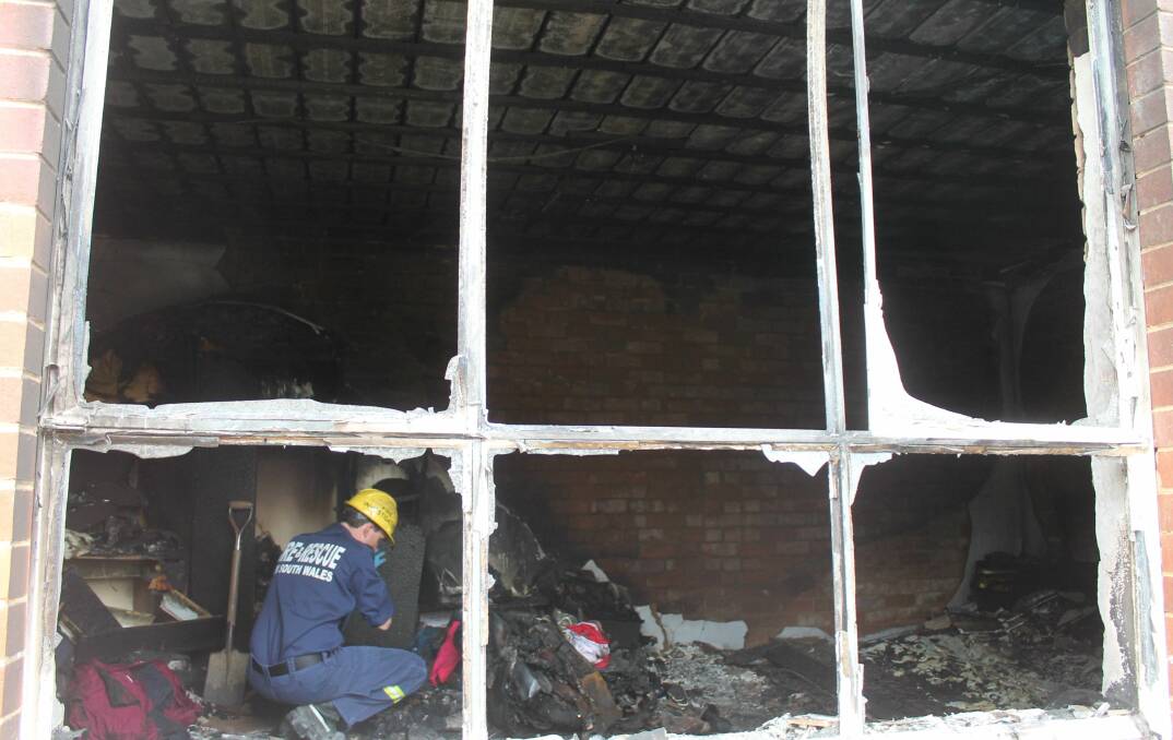 A NSW Fire Rescue investigator attempts to discern the cause of Sunday's fire. Photos: Andrew Johnston, Queanbeyan Age