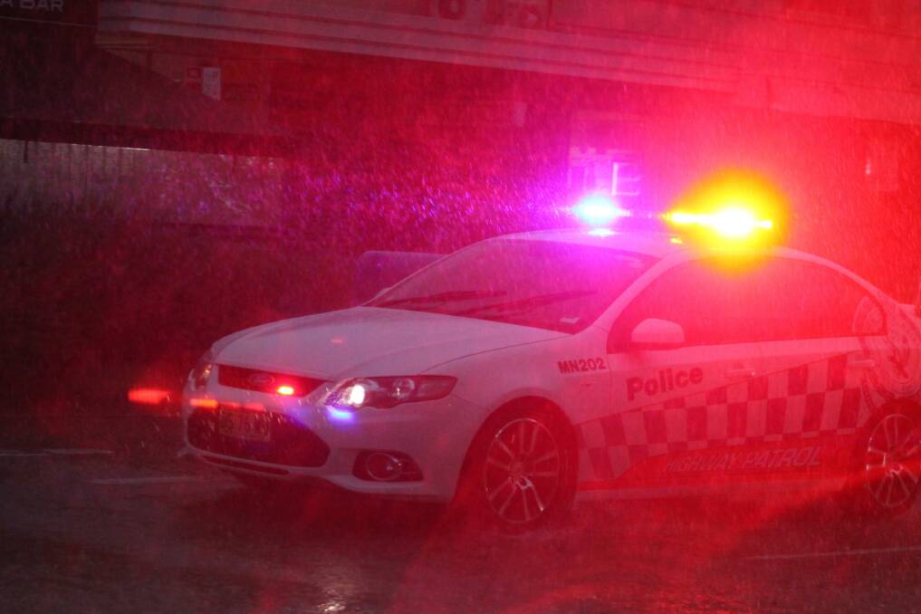 A police car makes it way through the wet weather. 