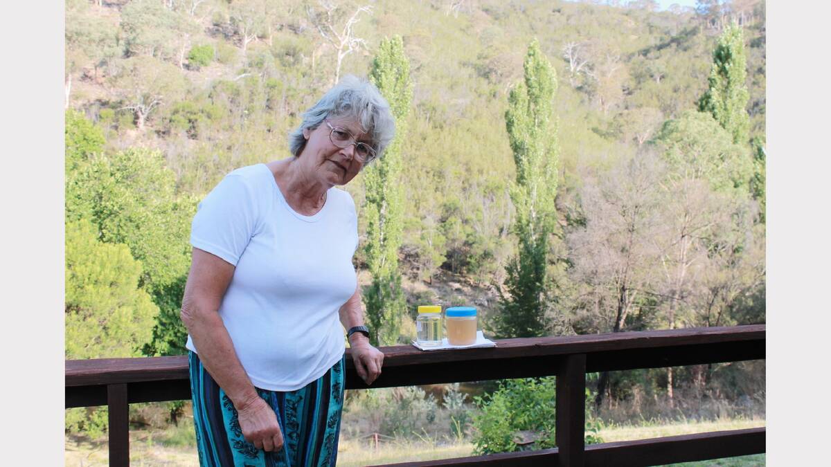 Wickerslack Lane resident Sue Gibson with Queanbeyan River samples taken before and after the Australia Day containment dam breach at Googong.