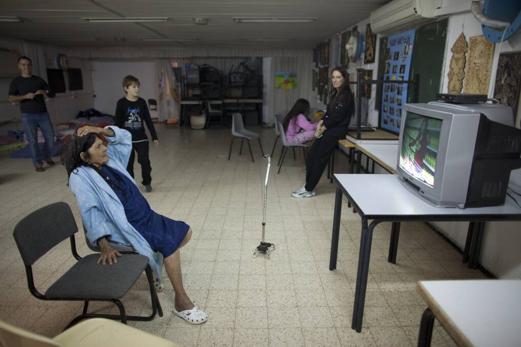Israelis watch TV in a bomb shelter in Netivot, Israel. Photo by Uriel Sinai/Getty Images