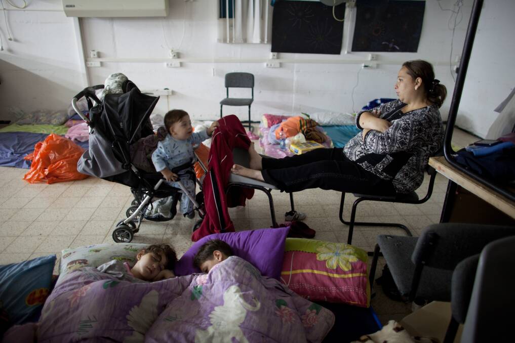 An Israeli woman and children sit inside a bomb shelter on November 14, 2012 in Netivot, Israel. Photo by Uriel Sinai/Getty Images