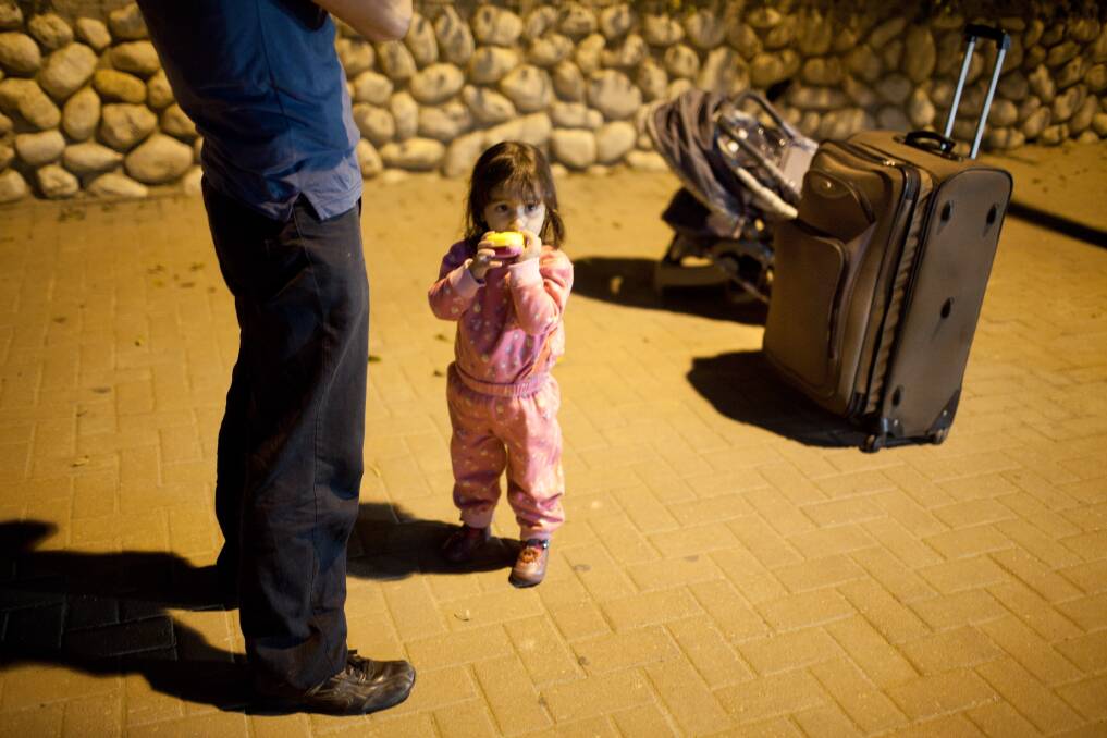 An Israeli man and child wait for a bus to leave town on in Netivot, Israel. Photo by Uriel Sinai/Getty Images