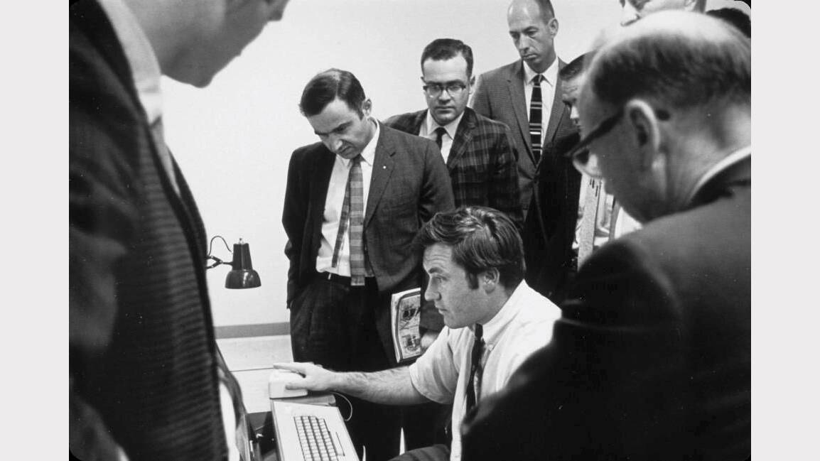 Former Queanbeyan resident Dr David Evans (seated) demonstrates the new computer mouse at the Stanford Research Institute in 1968.