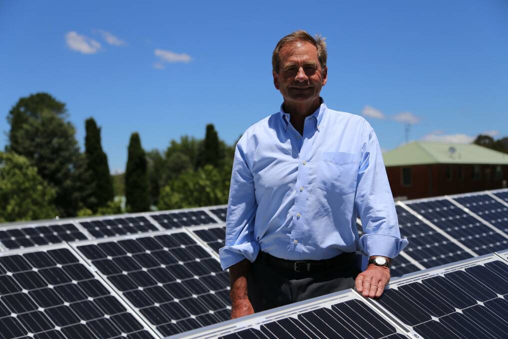 Queanbeyan Mayor Tim Overall inspects new solar panels atop the Queanbeyan Library, set to cut thousands of dollars off Council's energy bill. 