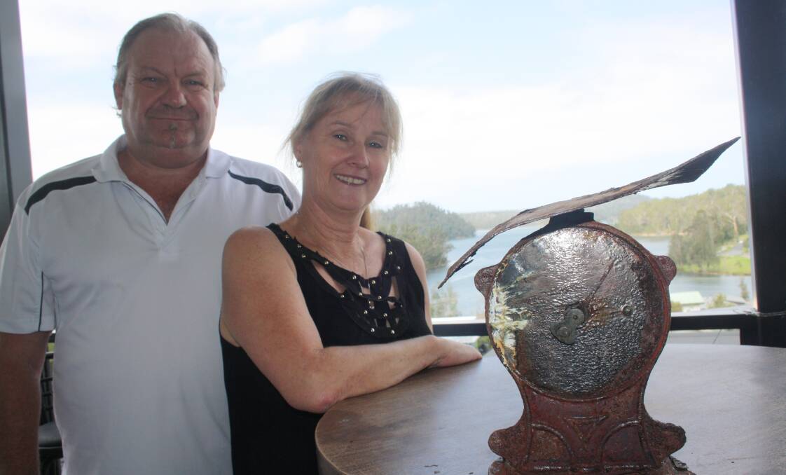 Ken and Katrina Walsh hold on to the few things salvaged when their Conjola Park home burnt to the ground five years ago, including two half-photographs and this scale. Picture by Glenn Ellard.