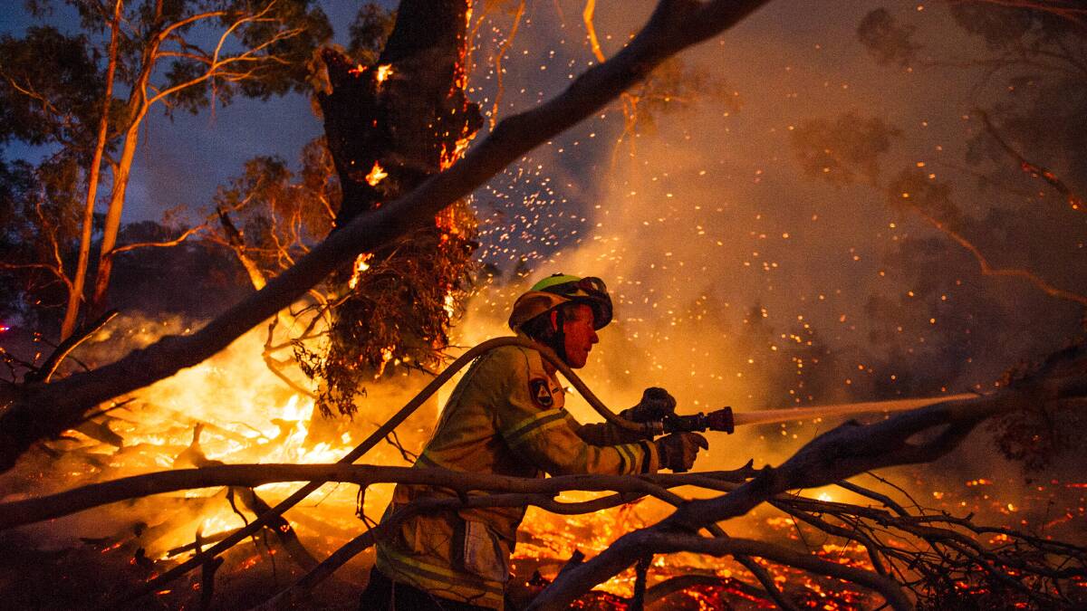A firefighter works to put out a bushfire near Braidwood, NSW. Picture by Dion Georgopoulos A firefighter works to put out a bushfire near Braidwood, NSW. Picture by Dion Georgopoulos