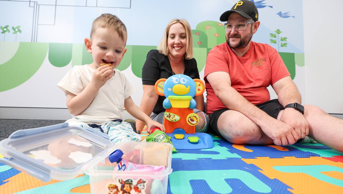 Three-year-old Harvey Lowcock, with parents Stacey and Shane, snacks on food from his lunchbox at Cerebral Palsy Alliance Wollongong, where he received life-changing therapy allowing him to try food for the first time. Picture by Adam McLean