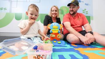 Three-year-old Harvey Lowcock, with parents Stacey and Shane, snacks on food from his lunchbox at Cerebral Palsy Alliance Wollongong, where he received life-changing therapy allowing him to try food for the first time. Picture by Adam McLean