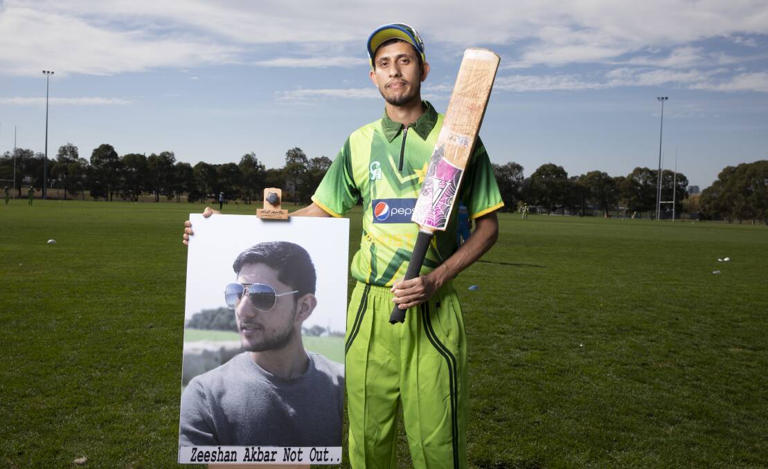 Faizan Akbar stands with a portrait of his brother Zeeshan at a cricket match dedicated to his memory. Photo: Sitthixay Ditthavong