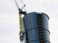 Four protesters climbed a 140-metre crane on a building next to Woodside's Perth headquarters. (HANDOUT/GREENPEACE)