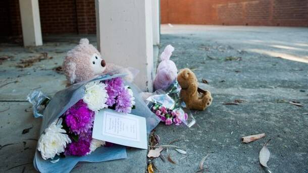 Floral tributes lay in front of the unit tower where a one-year-old girl died.  Photo: Elesa Kurtz.